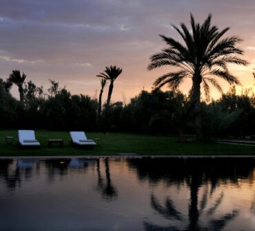 Luxurious all-inclusive resort pool in Marrakech, Morocco, bathed in golden autumn sunlight, symbolizing a relaxing and stress-free vacation escape.