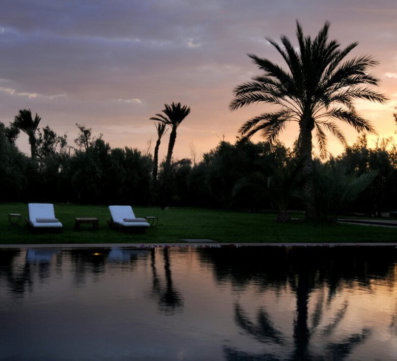 Luxurious all-inclusive resort pool in Marrakech, Morocco, bathed in golden autumn sunlight, symbolizing a relaxing and stress-free vacation escape.