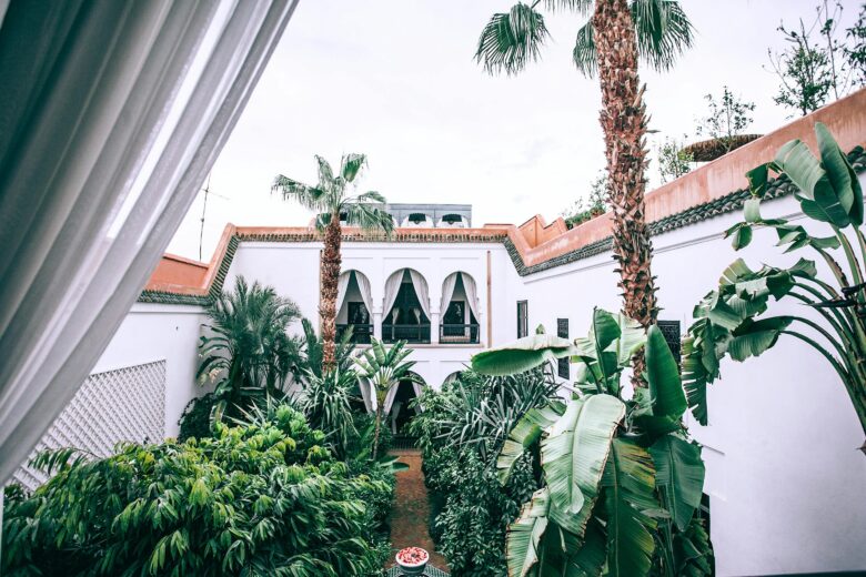 Luxury wellness retreat in Marrakech, Morocco: Serene woman practicing yoga in a lush resort garden, combining authentic Moroccan spa and meditation for holistic well-being.