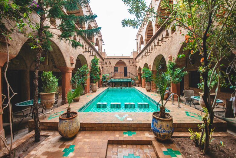 Happy British travelers relaxing at a luxury all-inclusive resort pool in Morocco, featuring traditional architecture near Marrakech. Ideal for stress-free family and couple vacations.
